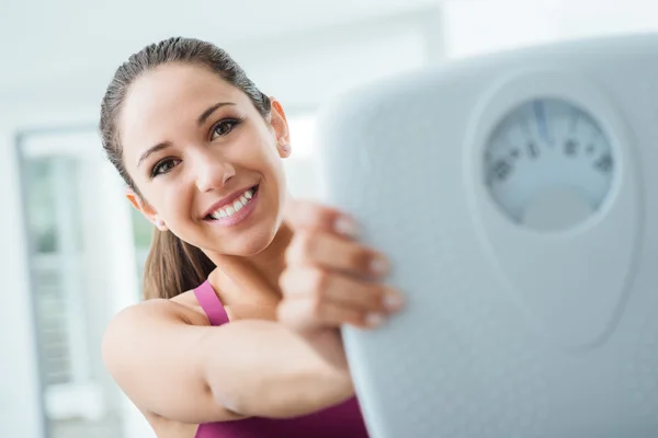 Happy woman showing a scale — Stock Photo, Image