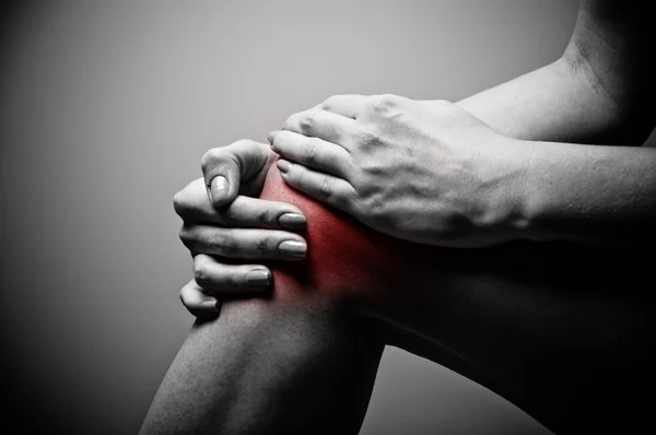 Understanding and Alleviating Knee Pain After Sitting with Legs Bent | Stock Photo