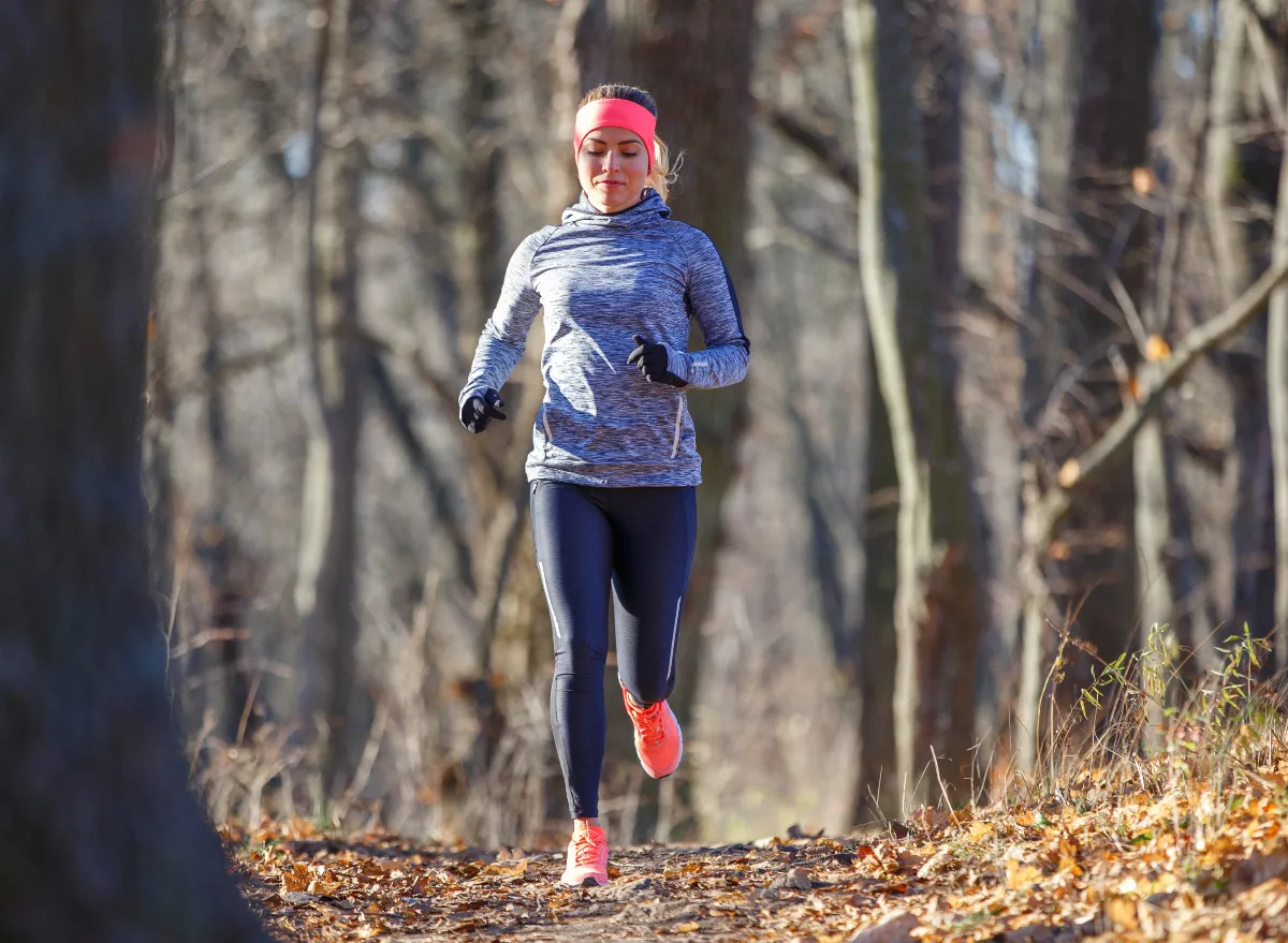 woman running through woodsy trail in the fall, concept of why you