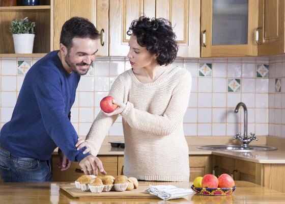 Man taking delicious cupcake while her woman offering him an app — Stock Photo, Image