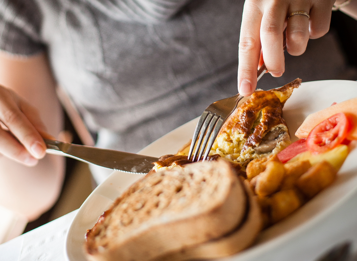 woman eating restaurant breakfast, concept of low-calorie breakfasts at major restaurant chains