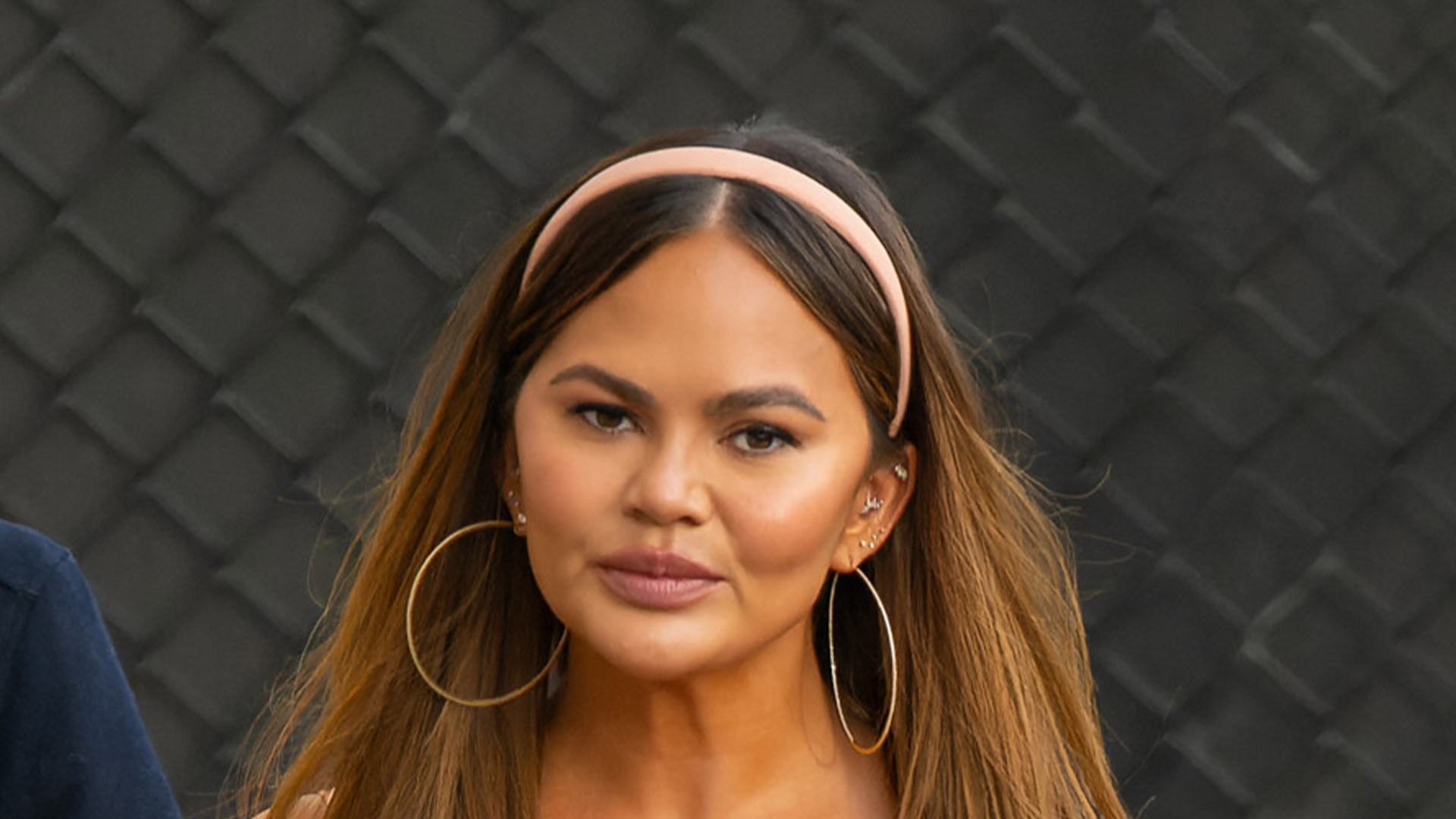 Chrissy Teigen stuns in dangerously short pink latex dress as she holds hands with husband John Legend in LA