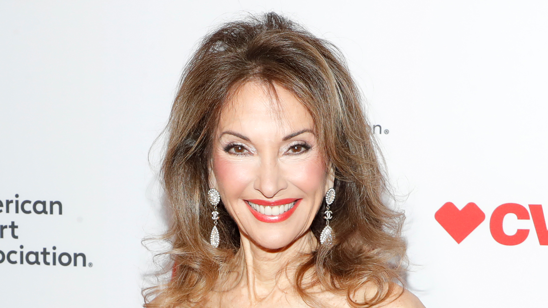 Soap star Susan Lucci, 77, looks ageless in a skintight strapless red gown as she cuddles up to cute pal at NYC gala