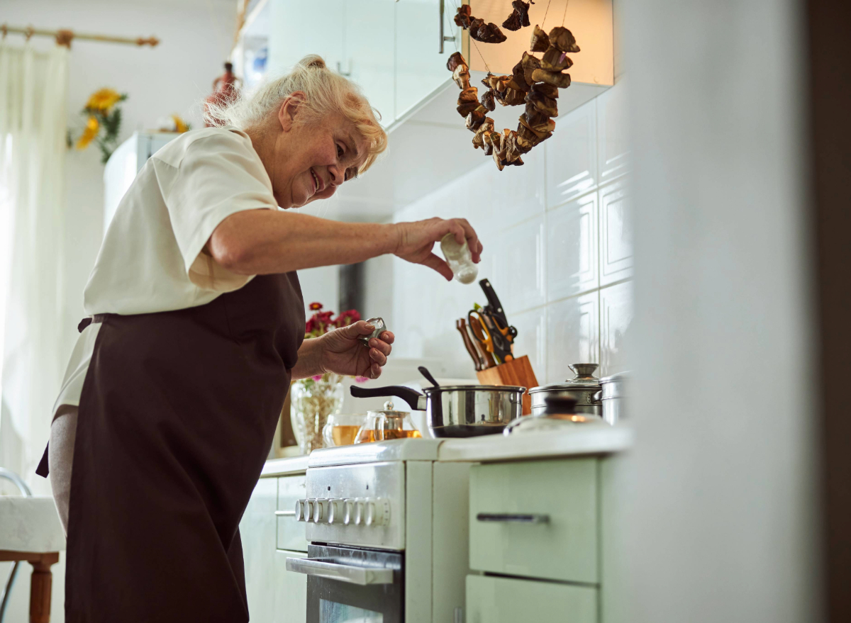 mature woman making soup in kitchen, concept of what world