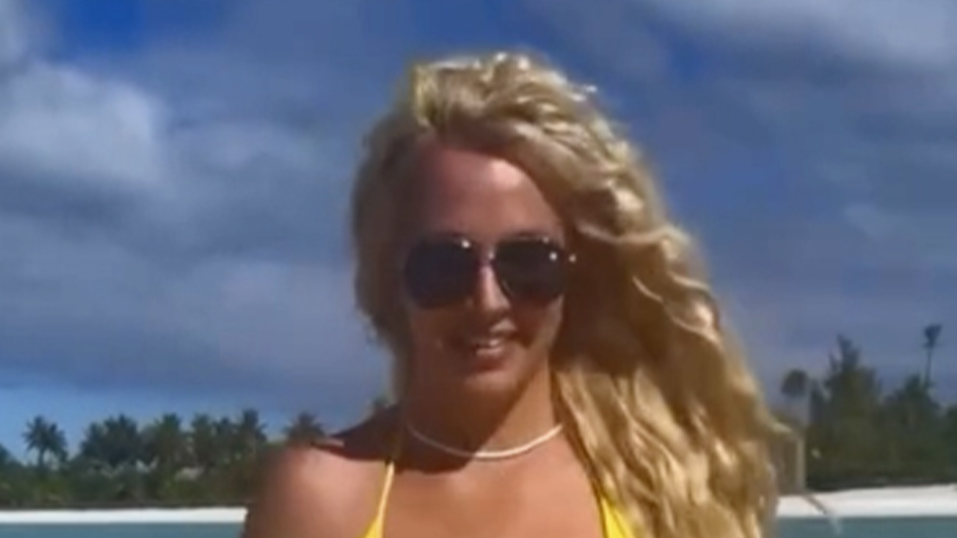 Britney Spears nearly suffers wardrobe malfunction in very tiny yellow bikini as star rocks beach look in sexy video