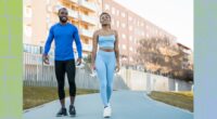 fit couple walking outdoors on paved path