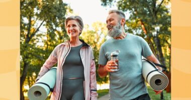 mature couple holding yoga mats walking to fitness class outdoors