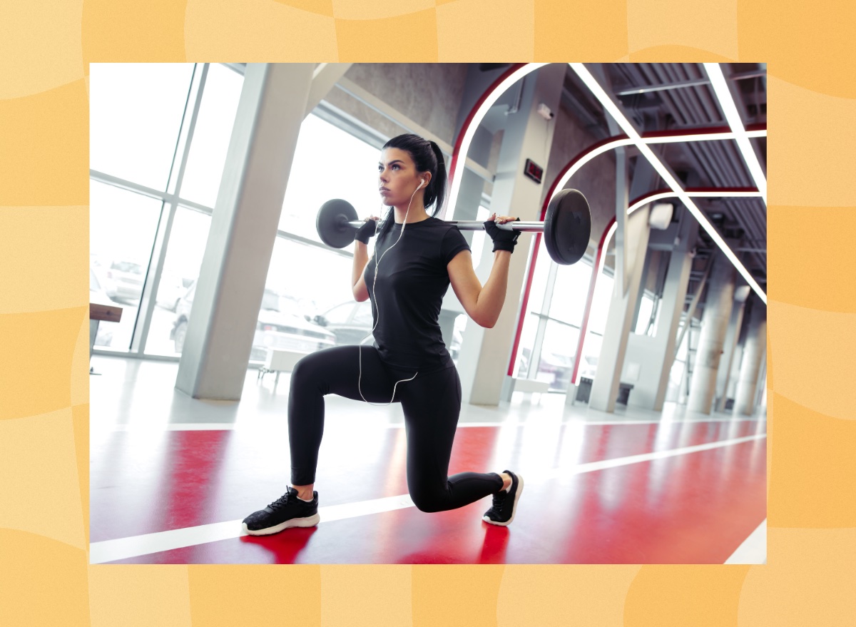 woman doing barbell lunges at the gym in front of windows