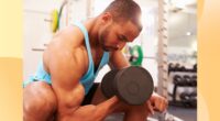 muscular man doing bicep curls at the gym