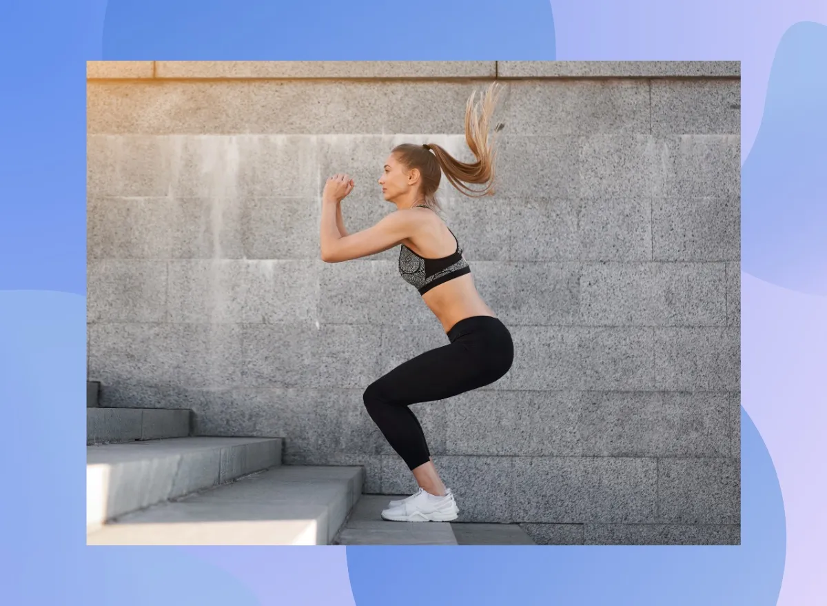woman doing jump squats outdoors on cement steps