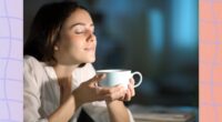 brunette woman holding cup of coffee at night