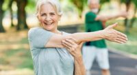 happy senior woman stretching outdoors