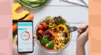 1,200-calorie diet concept, woman eating salad and checking calorie count on an app on her phone