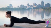 woman doing planks on a pier by the water next to city, concept of strength exercises to drop 10 pounds in a month