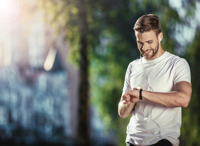 man checking his heart rate monitor on walk/run