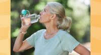 mature woman drinking water during workout outdoors