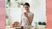 woman making healthy recipe, counting calories at home in bright kitchen