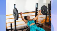 woman doing barbell bench press at the gym