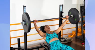 woman doing barbell bench press at the gym