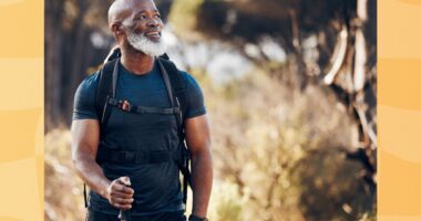mature man hiking outdoors on grassy trail