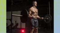 fit, muscular man doing barbell bicep curls in a dark gym setting