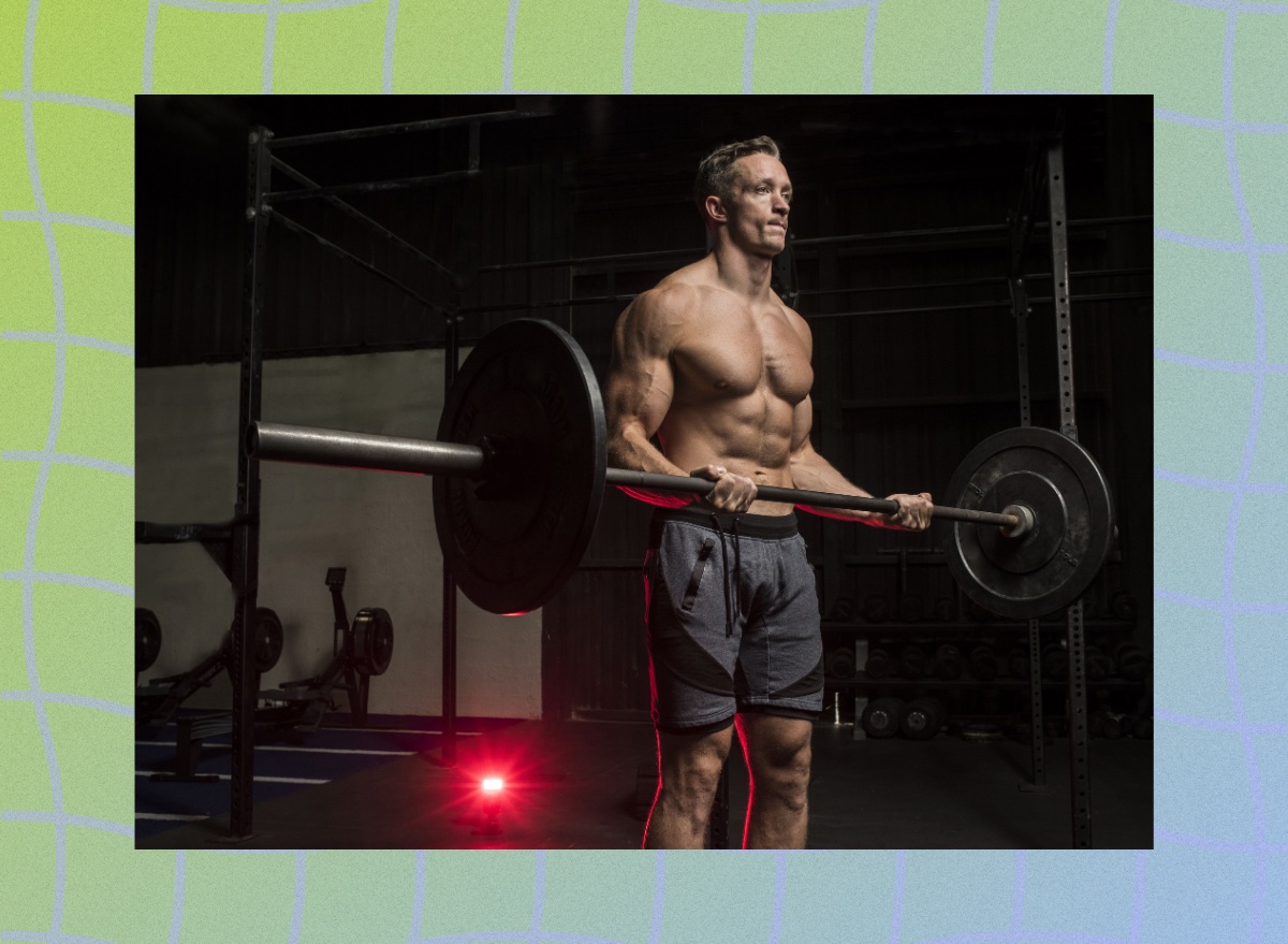 fit, muscular man doing barbell bicep curls in a dark gym setting