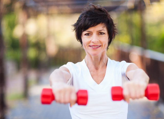 mature woman holding light dumbbells oudoors