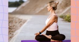 woman doing spinal twist on yoga mat outdoors