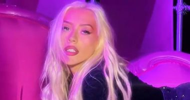 Christina Aguilera looks slimmer-than-ever as singer rolls around on couch in a mini skirt after 40lb weight loss