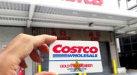 Costco membership card help up in front of warehouse