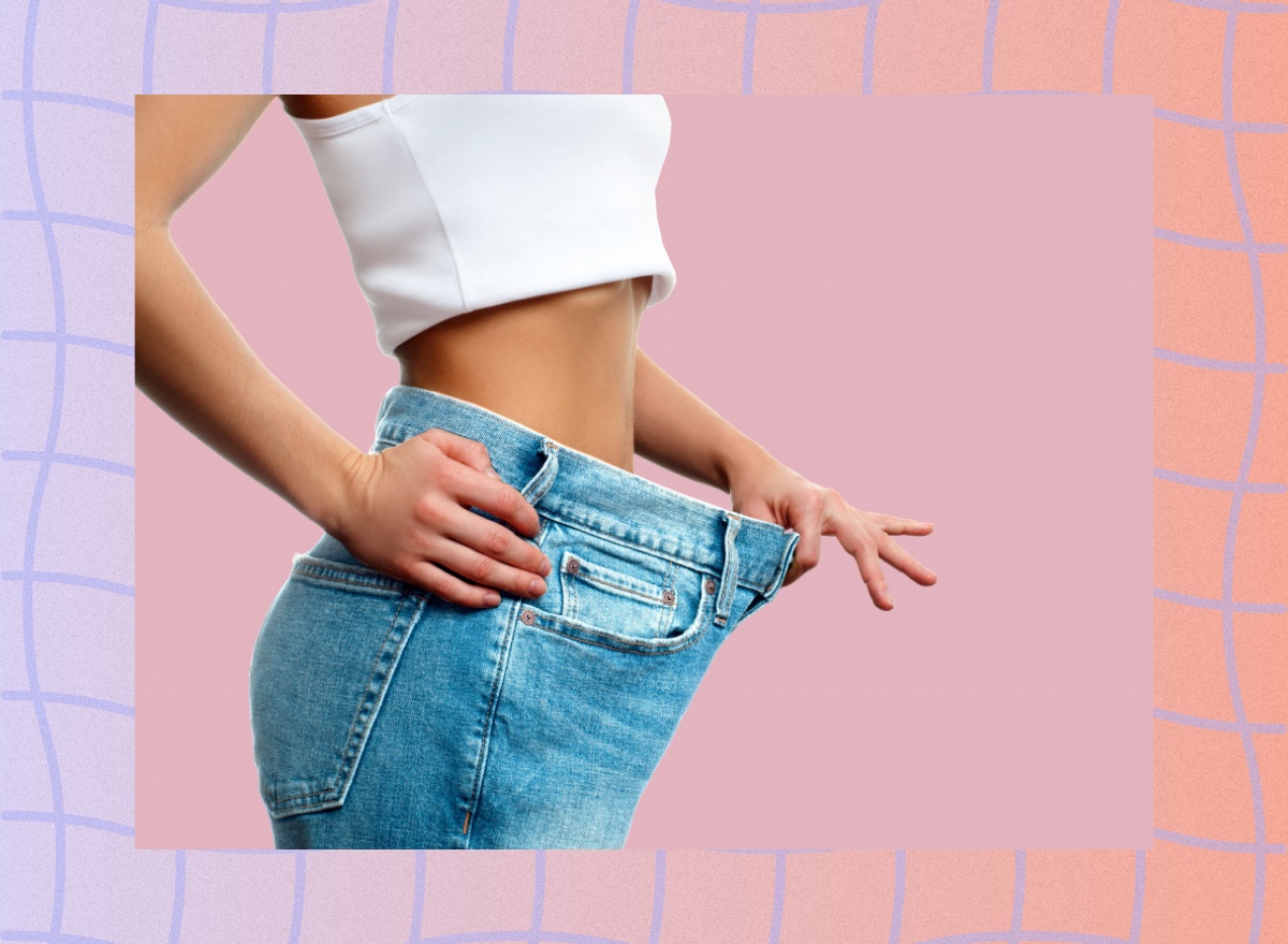 woman dropping pants and jeans size concept on pink background