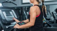 woman adjusting the treadmill incline at the gym