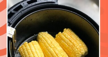 corn inside an air fryer on a red background