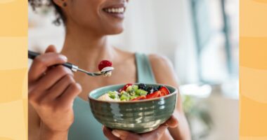 close-up of woman eating healthy yogurt bowl with fruit