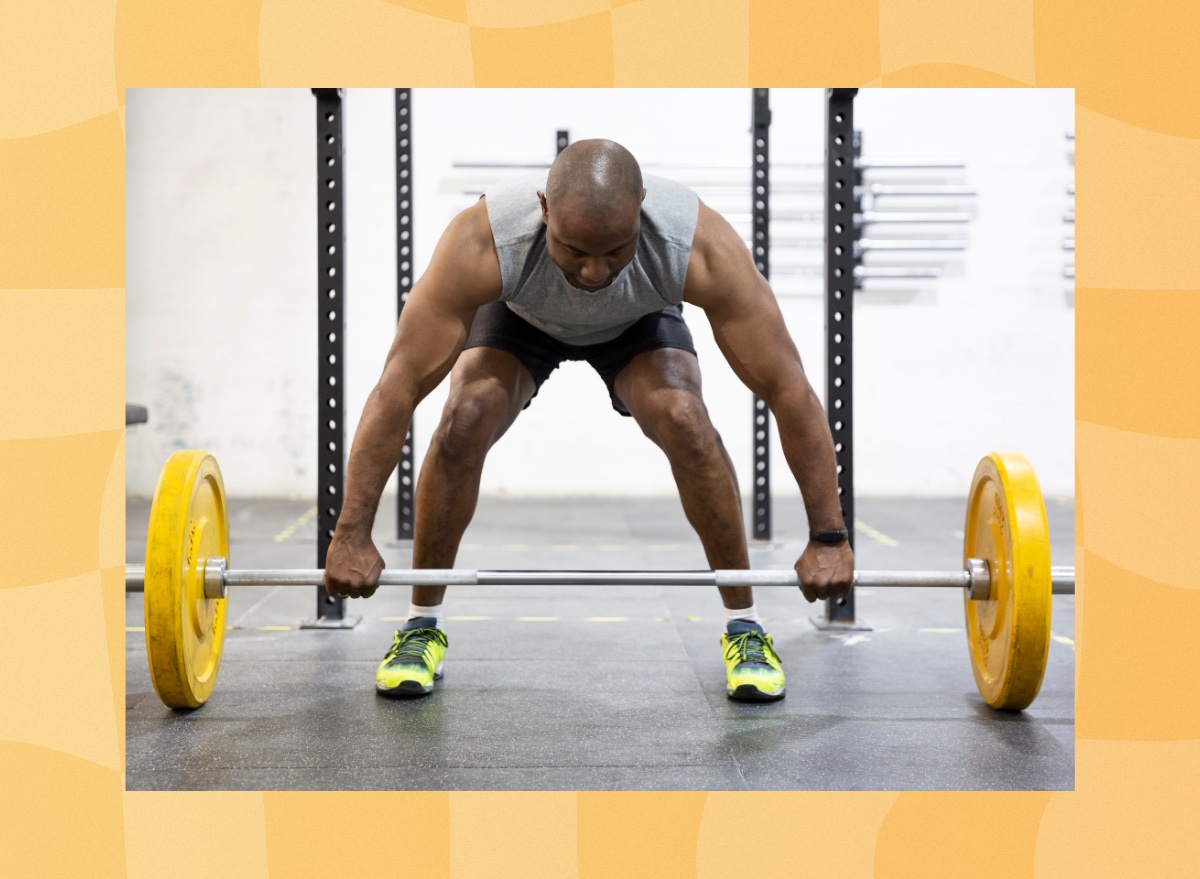 man lifting heavy barbell at the gym