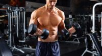 muscular man doing dumbbell bicep curls, concept of regular strength exercises for men