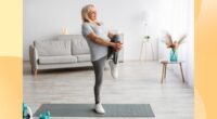 mature woman doing a single-leg balance exercise in bright living space