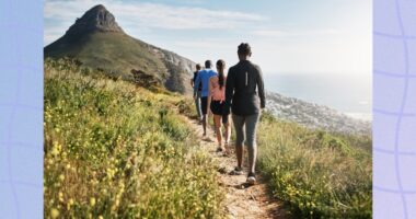 group of hikers walking nature mountain path by the sea