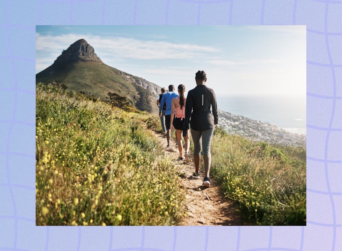 group of hikers walking nature mountain path by the sea