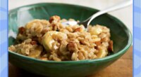 oatmeal with bananas almonds and peanut butter in a bowl with a blue border