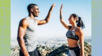 a photo of two fit people at the top of a mountain high-fiving each other on a designed greenish background