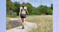 woman going on trail walk surrounded by grass and wildflowers on sunny day