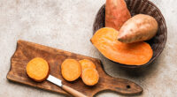 Composition with fresh sweet potato on light background