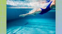 fit swimmer diving into deep end of pool, underwater shot