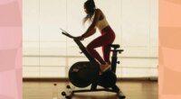 woman on exercise bike doing cycling workout in bright exercise room