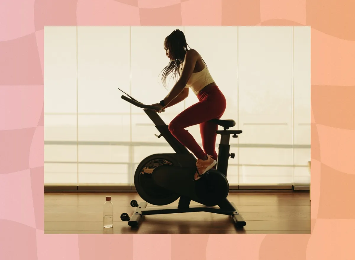 woman on exercise bike doing cycling workout in bright exercise room