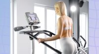 fit blonde woman using the stair climber machine at the gym in front of windows