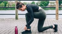 woman tying sneakers during walk with ankle weights