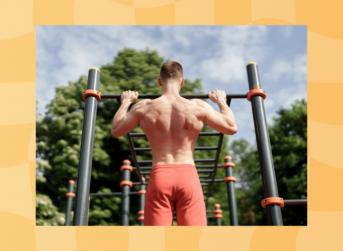 fit man doing pull-ups outdoors at park