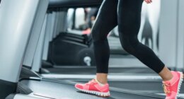 closeup woman walking on treadmill incline to speed up belly fat loss at gym during treadmill workout